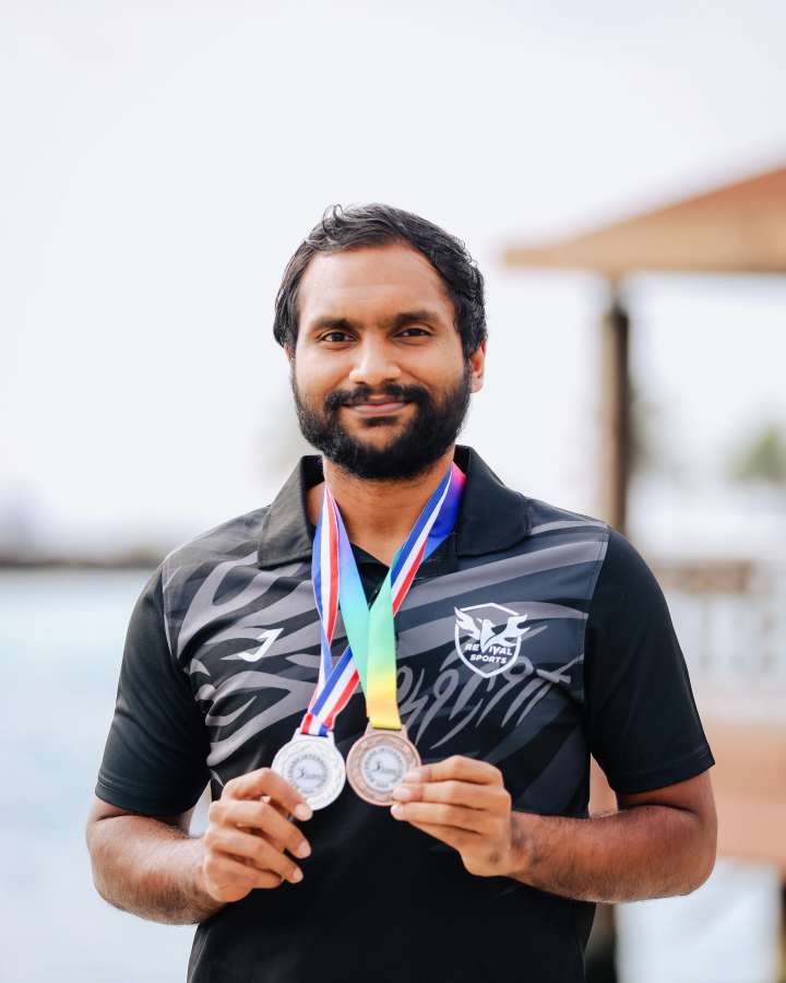 ހުޅުލެ، ދިވެހި ރާއްޖެ: ޒެމްބިއާ މުބާރާތާއި ބޮޓްސްވާނާ މުބާރާތުން ޖުމްލަ އެކު، ރިވައިވަލް ސްޕޯޓްސް އިން ވަނީ ގައުމީ ބެޑްމިންޓަން ޓީމުގެ ކުޅުންތެރިން ހިމެނޭހެން ވާދަކޮށް ރާއްޖެ އަށް ޖުމްލަ އެކު އަށް މެޑަލް ހޯދައިދީފައި: އެ ގޮތުން، މި މެޑަލްތަކުގެ ތެރޭގައި ތާރީހީ ކާމިޔާބީތައް ވެސް ހިމެނޭއިރު މިއަދު ކުޅުންތެރިން އެނބުރި ގައުމަށް އައުމުން މަރުހަބާ ކިއުމުގައި ބައިވެރިވީ ރިވައިވަލްގެ މެނޭޖްމަންޓާއި އާއިލާ މެމްބަރުން: ރިވައިވަލްގެ އިސް ކުޅުންތެރިޔާ، ޒަޔާން، އޭނާ ވެސް ވަނީ ދެ މުބާރާތުގައި ތިން މެޑަލް ހޯދައިފައި.-- ފޮޓޯ: މިރާޝް ނާޝިމް / އަދަދު  