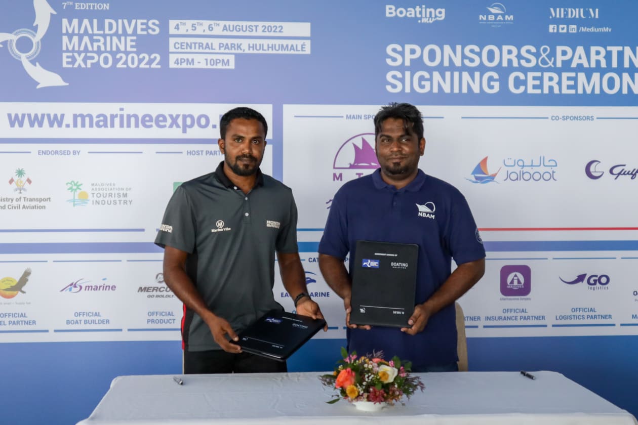 ޖުލައި 6، 2022: މެރިން އެކްސްޕޯގެ އޮފިޝަލް މެރިން އިންޖީންގެ އެއްބަސްވުމުގައި މެރިން ވައިބްއިން ސޮއިކުރުމަށް ފަހު، މީޑިއަމް ޕްރައިވެޓްގެ މެނޭޖިން ޑިރެކްޓަރު ޝާމް މުހައްމަދުއެކު ފޮޓޯއަކަށް ހުއްޓިގެން -- ފޮޓޯ: މުހައްމަދު ޝާބިން/ އަދަދު