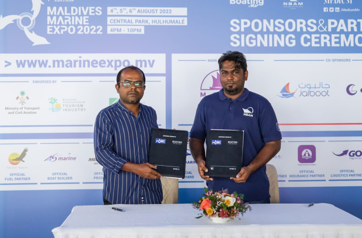 ޖުލައި 6، 2022: މެރިން އެކްސްޕޯގެ މީޑިއާ ޕާޓްނަރުގެ އެއްބަސްވުމުގައި އަދަދު ނޫހުގެ ސީއީއޯ ހުސައިން ފިޔާޒު އަދި މީޑިއަމް ޕްރައިވެޓްގެ މެނޭޖިން ޑިރެކްޓަރު ޝާމް މުހައްމަދު ސޮއިކުރެއްވުމަށް ފަހު ފޮޓޯއަކަށް ހުއްޓިގެން -- ފޮޓޯ: މުހައްމަދު ޝާބިން/ އަދަދު