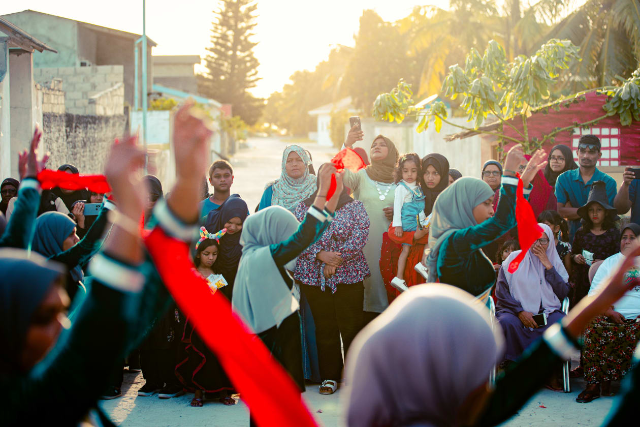 ކޯޑި ދުއްވާ މަންޒަރު ބަލަން ރަސްގަތީމުގެ ކުދިބޮޑު ރައްޔިތުން ނުކުމެ އެކި ސަރަހައްދުތަކުގައި ތިބި. ކޯޑި ދުއްވީ އެރަށު ބޮޑެތި މަގުތަކުގައި -- ފޮޓޯ: މިރާޝް ނާޝިމް / އަދަދު