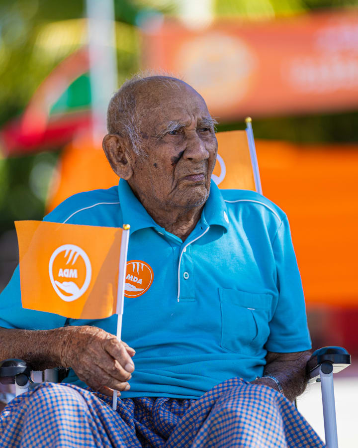 އޯގަސްޓް 7، 2023: ހުޅުދެލިން ރައީސް ސޯލިހަށް މަރުހަބާ ކިޔަން ނުކުމެ ހުރި އެމްޑީއޭގެ ސަޕޯޓަރެއް. -- ފޮޓޯ: އަބްދުﷲ އިޔާން / އަދަދުދު