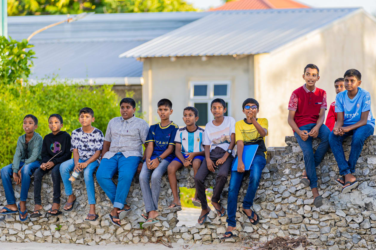އޯގަސްޓު 7، 2023: ހުޅުދެއްޔަށް ރައީސް ސޯލިހު ވަޑައިގެންނެވި ވަގުތު އެ ރަށުގެ ޒުވާން ކުދިންތަކެއް ފާރުބުރި މަތީގައި އިށީނދެ ލައިގެން -- ފޮޓޯ: އަބްދުﷲ އިޔާން / އަދަދު 