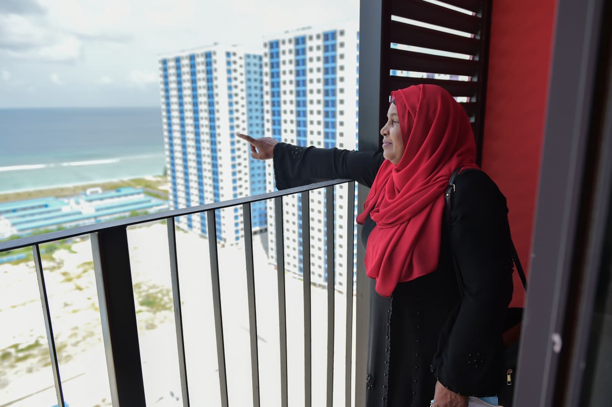 ފްލެޓް ލިބުނި މީހެއް އޭނަގެ ފްލެޓްގެ ބެލްކަނިން ބޭރު ބަލާލަނީ.. ފޮޓޯ: ހުސައިން ޝަޔާޙް / އަދަދު
