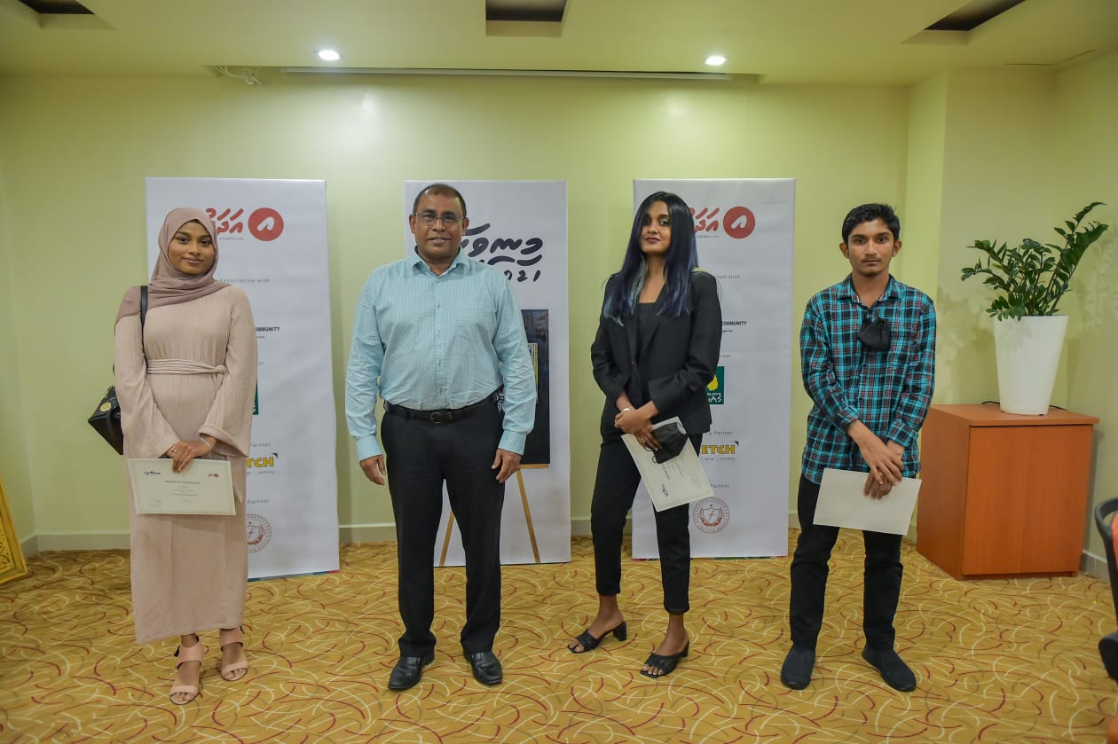 މޯލްޑިވިއަން އާޓިސްޓް ކޮމިއުނިޓީ (މެކް) އާ ގުޅިގެން "އަދަދު"ން ކުރިއަށް ގެންދިޔަ "މިނިވަން ފިހި" ކުރެހުމުގެ މުބާރާތް ނިންމުމުގެ ހަފުލާގެ ތެރެއިން: މުބާރާތުން އެއްވަނަ ދެވަނަ އަދި ތިންވަނައަށް ދިޔަ ބައިވެރިންނާއިއެކު ޓޫރިޒަމް މިނިސްޓަރު އަބްދުﷲ މައުސޫމް ފޮޓޯއަކައް ހުއްޓިލައިގެން - ފޮޓޯ: ހުސެއިން ޝަޔާހު / އަދަދު