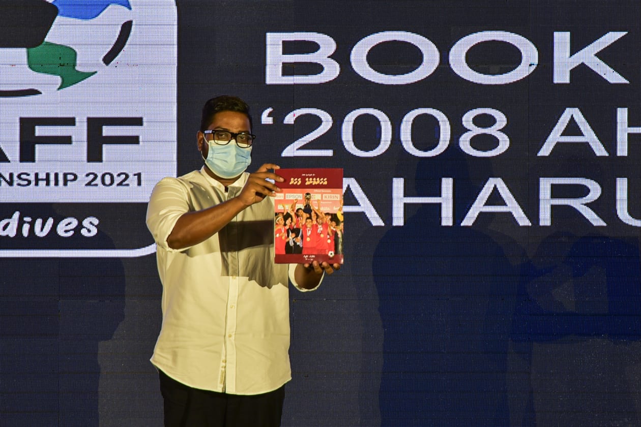 ސެޕްޓެމްބަރު 12، 2021: އަންނަ މަހު 1-16 އަށް ރާއްޖޭގައި ބޭއްވުމަށް ނިންމާފައިވާ ސާފް ޗެމްޕިއަންޝިޕްގެ ޕްރޮމޯޝަނަލް ކެމްޕެއިން ފެއްޓުމަށް ބޭއްވި އިވެންޓްގެ ތެރެއިން: ރާއްޖޭން އެންމެ ފުރަތަމަ 2008 ވަނަ އަހަރުގެ ސާފް ޗެމްޕިއަންކަން ހޯދިއިރު އެ މުބާރާތާ ގުޅޭ ގޮތުން ކުޅިވަރު ނޫސްވެރިޔާ އަބްދުﷲ އަޒްމީން ލިޔުނު ފޮތް ރަސްމީކޮށް އިފްތިތާހުކޮށްދެއްވީ އެފްއޭއެމްގެ ރައީސް ބައްސާމް އަދީލް ޖަލީލް-- ފޮޓޯ: ހުސެއިން ޝަޔާހު/ އަދަދު