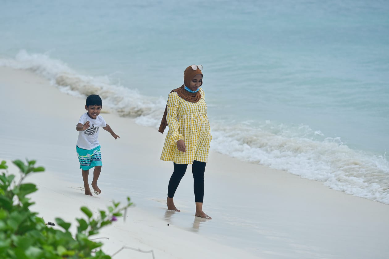 ކާފިއު ވަގުތުގެ ކުރިން ކުޑަ އީދު ފާހަގަކޮށްލުމަށްޓަކައި ހުޅުމާލެ ބީޗުގައި މީހަކު ދަރިފުޅާއެކު ހިނގާލަނީ: ފޮޓޯ: ހުސައިން ވަހީދު / އަދަދު