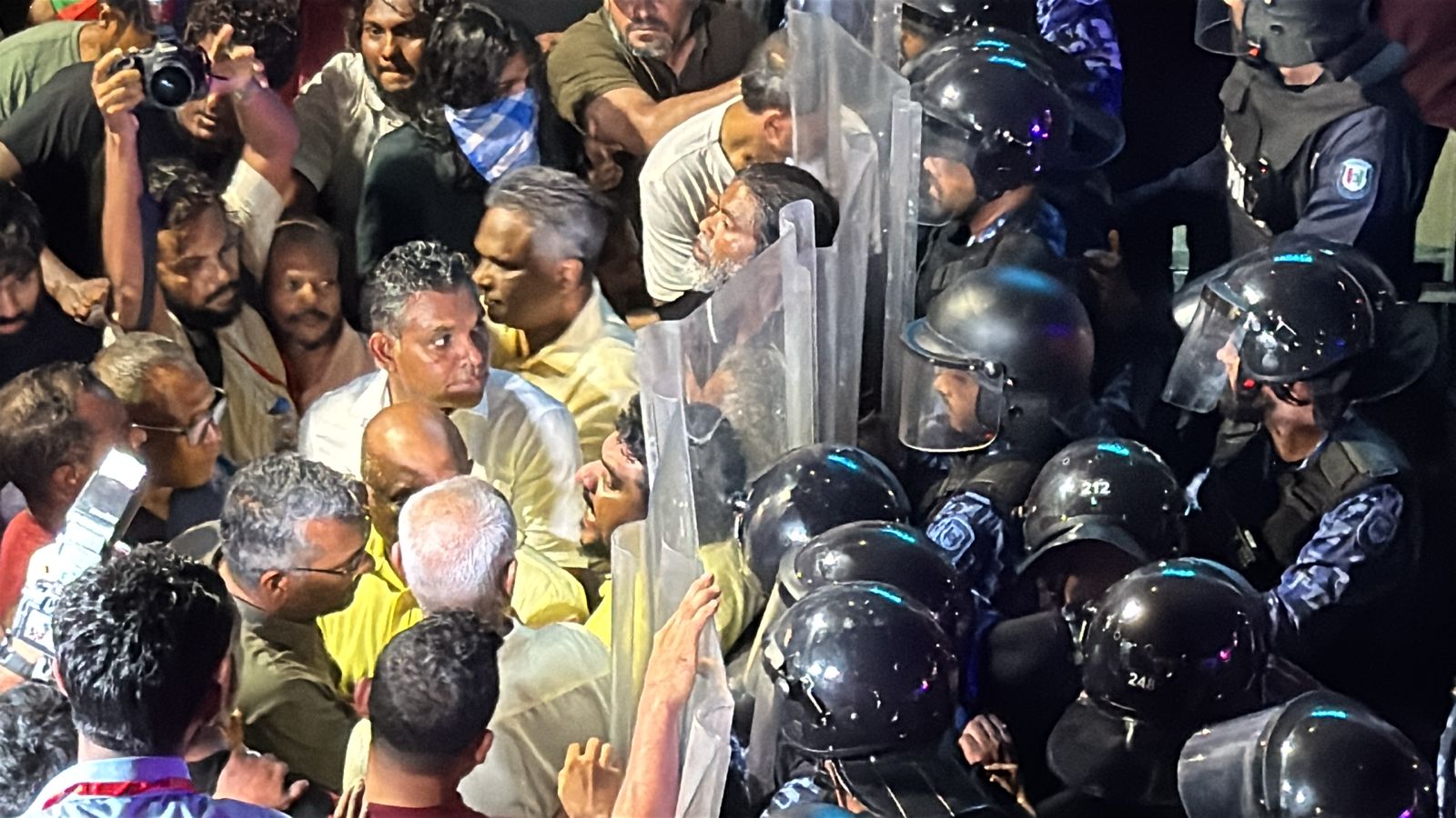 އޮކްޓޯބަރު 3، 2025: މުޒާހަރާގައި ކުރީގެ ރައީސުލްޖުމްހޫރިއްޔާ އިބްރާހިމް މުހައްމަދު ސޯލިހު ކުރީގެ ނައިބު ރައީސް ފައިސަލް ނަސީމް އާއި އެމްޑީޕީގެ ޗެއާޕާސަން ފައްޔާޒު އަދި ޕާޓީގެ ރައީސް ޝާހިދު އާއި އާއި އެމްޑީޕީގެ ލީޑަޝިޕްގެ ބައެއް މީހުން ފުލުހުންގެ ޝީލްޑުތަކާ ޖެހިގެން ކުރީ ސަފުގައި. -- ފޮޓޯ: ހުސައިން ފިޔާޒު މޫސާ