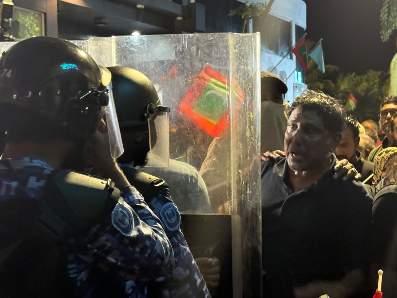 އޮކްޓޯބަރު 3، 2025: ރައްޔިތުންގެ ހާއްސަ މަޖިލީހުގެ ކުރީގެ މެންބަރު ޝަފީގު، ޝީލްޑުތަކުގެ ދޭތެރެއިން ފުލުހުންނާ ވާހަކަ ދައްކަނީ. -- ފޮޓޯ: ހުސައިން ފިޔާޒު މޫސާ