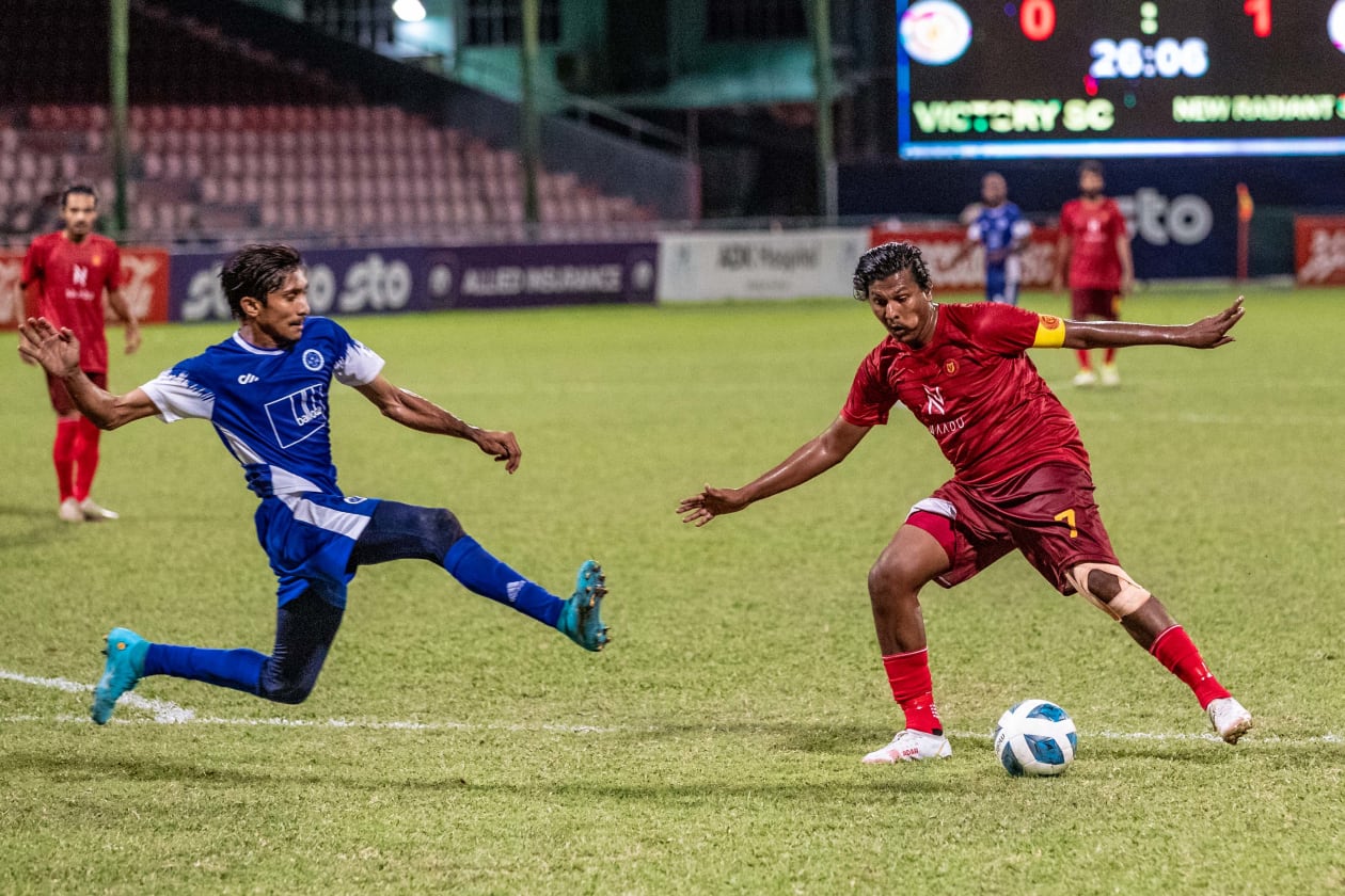 މާލެ، 24 ޖުލައި 2022: އީ 2018 ވަނަ އަހަރުގެ އޮކްޓޫބަރު މަހުގެ 30 ގެ ފަހުން ވިކްޓަރީ އާއި ނިއު ރޭޑިއަންޓުން ރަސްމީ މެޗެއްގައި ވާދަކުރި ފުރަތަމަ ފަހަރު: ސަސްޕެންޝަނަކަށް ފަހު ދެ ޓީމުން ފުޓްބޯޅަ އަށް އެނބުރި އައިސް މި ފަހަރުގެ ދެ ވަނަ ޑިވިޝަނުގައި ކުޅޭއިރު، މި ދެ ޓީމުގެ މެޗު ވައިގައި ހިފީ "ރަސްވާދަ ނަމުން: ނިއު އިން ވަނީ ވިކްޓަރީގެ މައްޗަށް 4-1 އިން ކުރިހޯދާފައި: ވިކްޓަރީގެ އާއްކޮ (ކ) އަތުން ބޯޅަ ހޯދަން ނިއުގެ ޝަމްވީލް ޓެކަލް ކުރަނީ-- ފޮޓޯ: އިމޭޖަސް.އެމްވީ