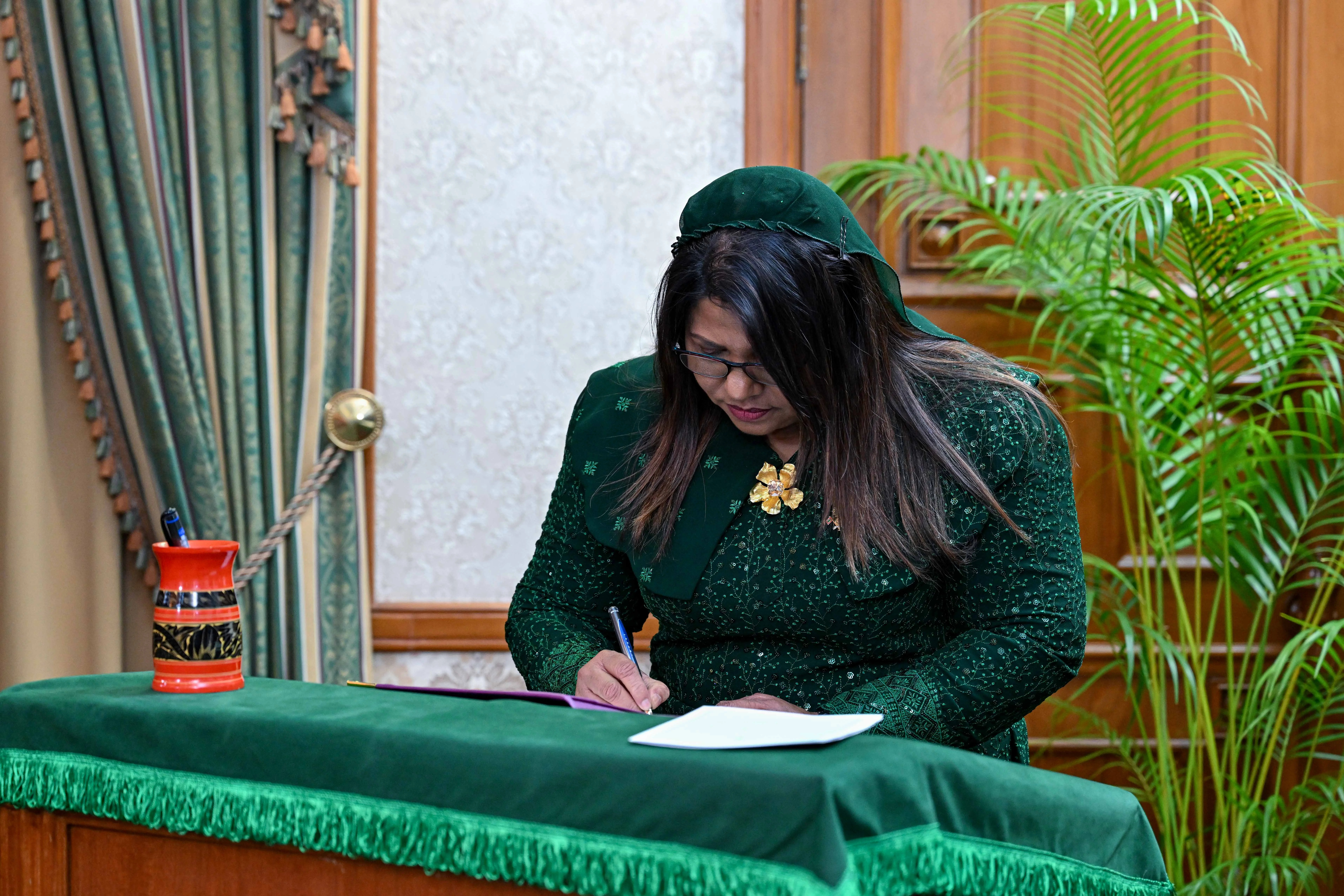 Minister of Health, Family and Welfare, Geela Ali, signs the instrument of appointment.