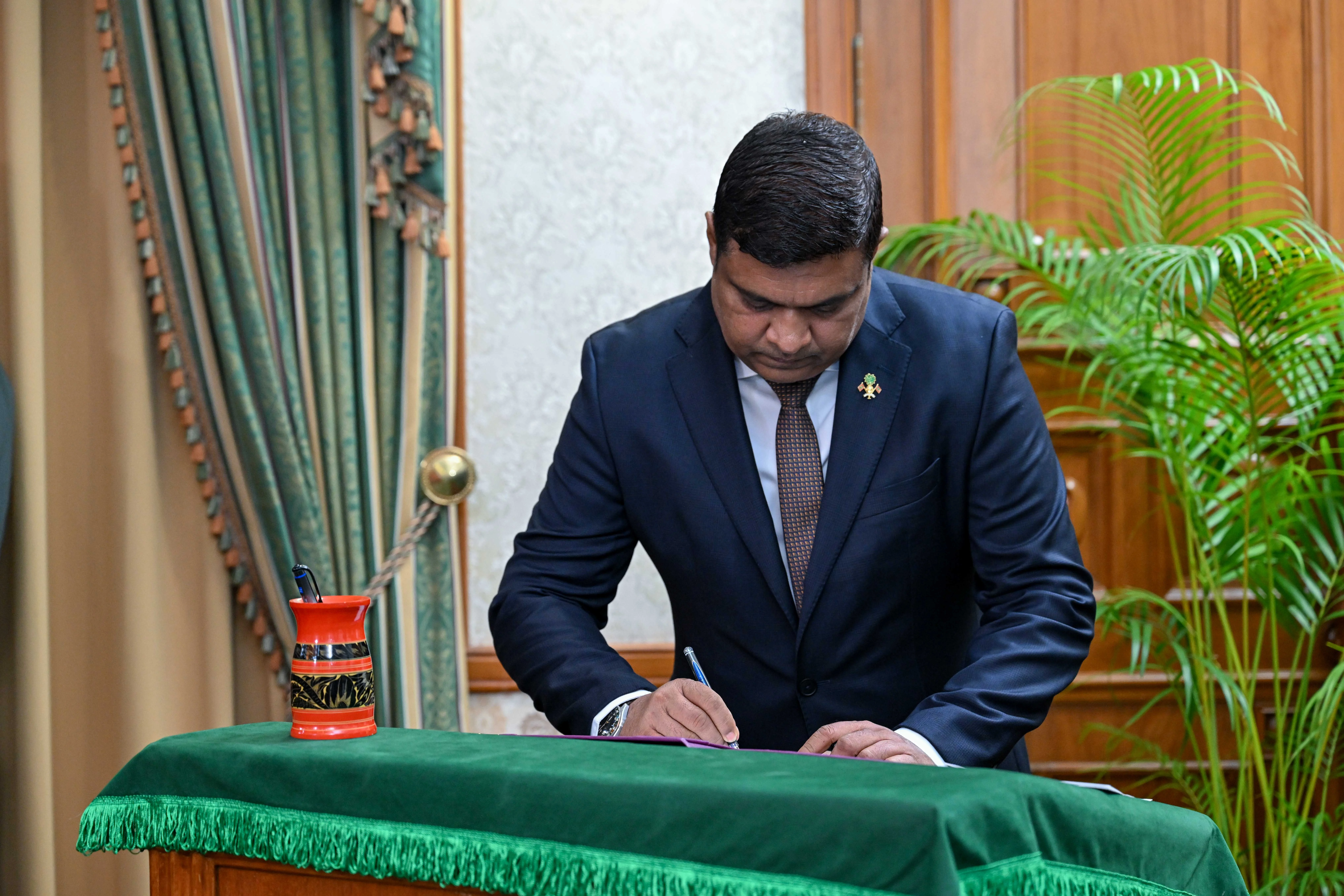 Minister of Tourism and Civil Aviation Ibrahim Faisal signs his letter of appointment.