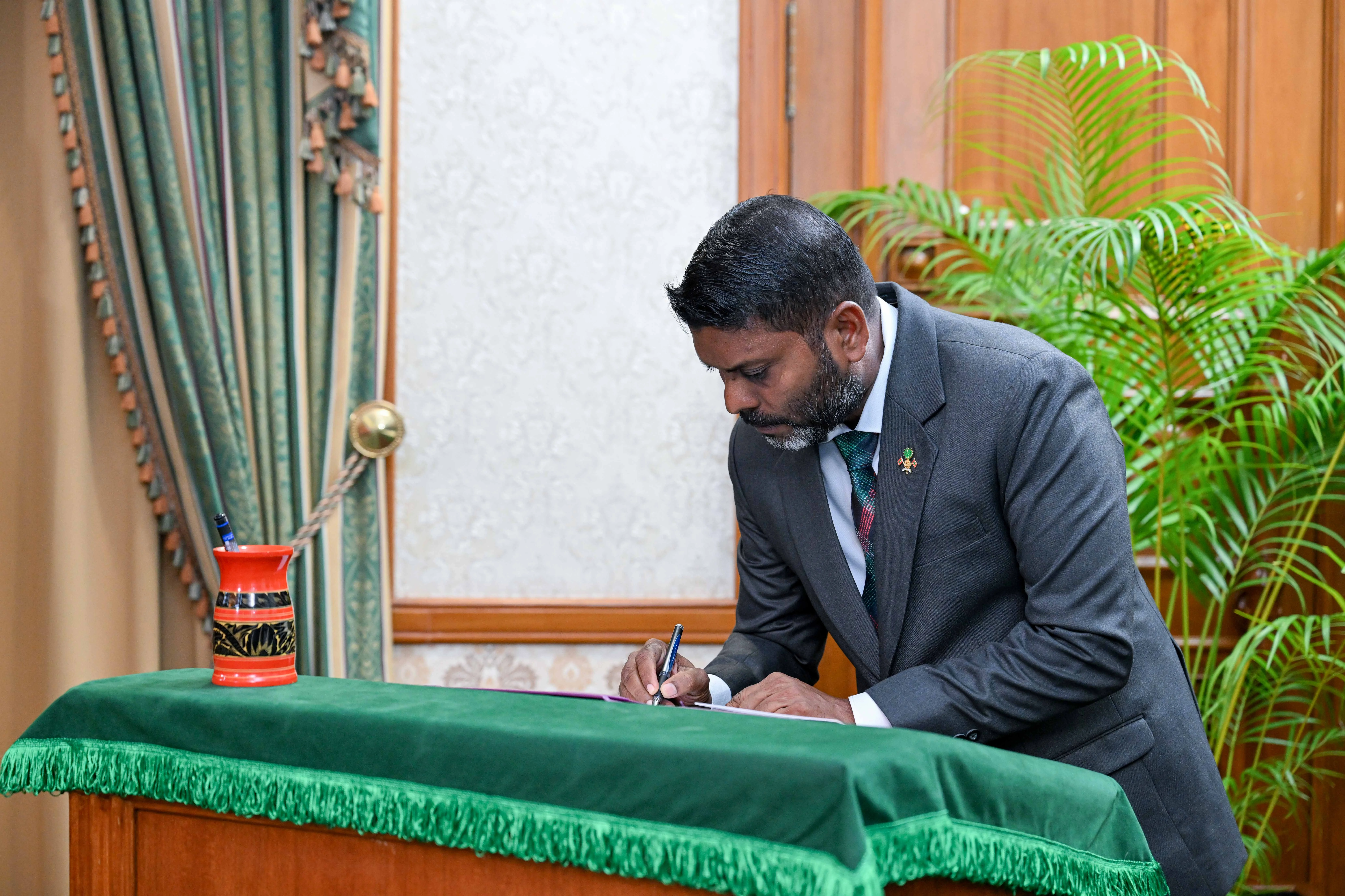 Minister of Youth Empowerment, Sports and Fitness Ibrahim Rafiu signs his letter of appointment.