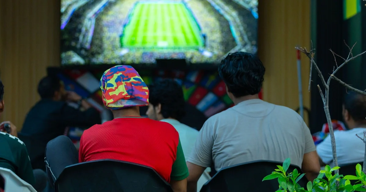 A group of people seen sitting on chairs lined up along the street in the early hours of the morning to watch a match on a television set outside a cafe in Hulhumale. -- Photo: Mohamed Shahuzaan / Adhadhu